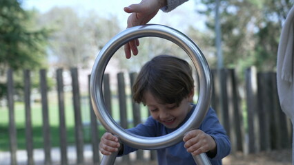 Child spinning at playground spinner structure. One little boy having fun at play space with stainless steel toy