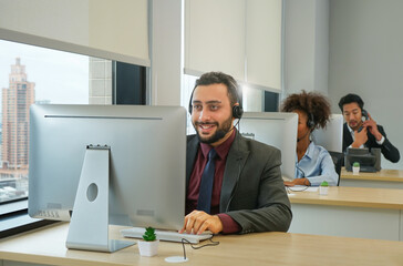young man in a good mood working in customer service agent at the call center office, concept call...