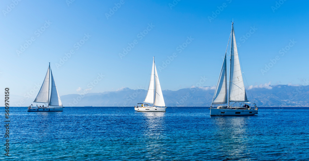 Wall mural sailing yacht boats with white sails in blue sea , seascape of beautiful ships in sea gulf with mountain coast on background