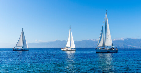 Plakat sailing yacht boats with white sails in blue sea , seascape of beautiful ships in sea gulf with mountain coast on background
