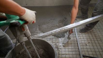 Workers pour self-leveling floor. Pouring Self-Leveling Floors. Self-Leveling Floors On A Large Area, A Worker. Self-leveling epoxy. Leveling with a mixture of cement floors.