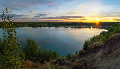 Fototapeta na wymiar Sunset over the horizon and at the water quarry . Leningrad region. Vsevolozhsk.