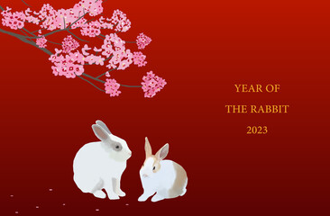Real life drawing of couple of rabbits sitting under a blossom tree with a year of rabbit text.