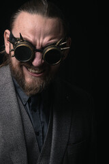 charismatic man in a classic suit and steampunk goggles on a black background stylish Portrait