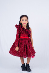 Little model girl isolated on white background. Asian child wearing red dress and posing in studio. 