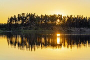 Naklejka premium Sunset over the horizon and at the water quarry . Leningrad region. Vsevolozhsk.