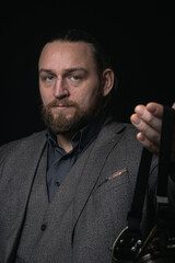 charismatic man in a classic suit and steampunk goggles on a black background stylish Portrait