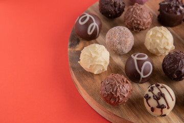 photo round chocolates on a round wooden board on a red background