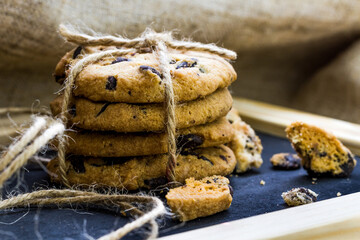 Close-up view of freshly baked chocolate chip cookies on dark wooden background