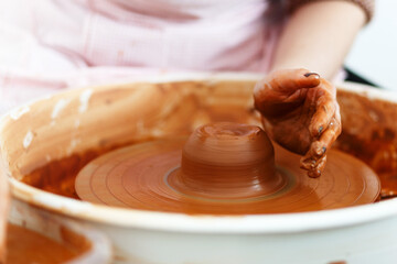 Potter creates a pitcher on a pottery wheel