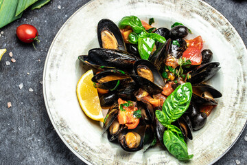 Cooked mussels with lemon and parsley on table. Food recipe background. Close up