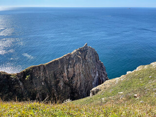 Trail along the edge of the cliff on the island of Shkota in September in sunny weather. Russia,...