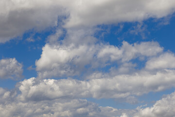 Bright blue sky with lots of broken cumulus white clouds of various shapes and sizes