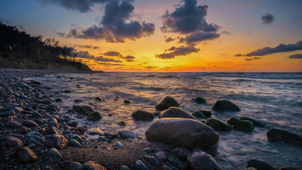 Wonderful orange sunset on the rocky coast of the sea