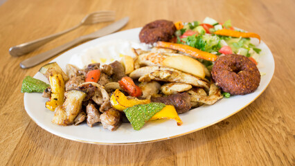 Falafel combo dish with vegetables. Faláfel or falafel​ is a chickpea or broad bean croquette. It is usually consumed in the Middle East.