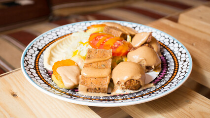 Falafel combo dish with vegetables. Faláfel or falafel​ is a chickpea or broad bean croquette. It is usually consumed in the Middle East.