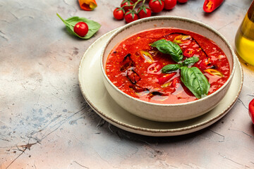 Bowl of traditional spanish cold soup puree gazpacho on a light background. Detox and healthy superfoods bowl concept