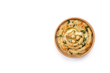 Chickpea hummus in a wooden bowl garnished with parsley, paprika and olive oil isolated on white background. Top view. Copy space