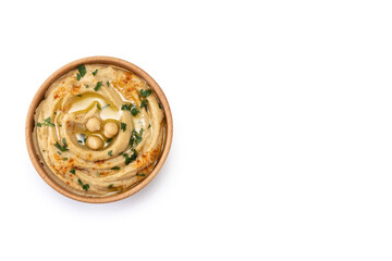 Chickpea hummus in a wooden bowl garnished with parsley, paprika and olive oil isolated on white background. Top view. Copy space