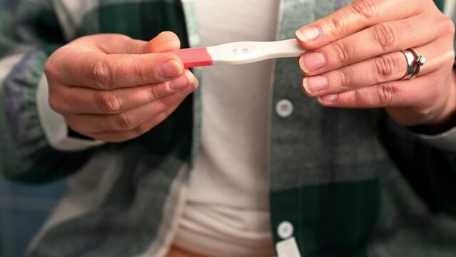 Cropped view of woman's hands unpacking and removing home pregnancy test from package. Maternity and gynecology concept. Fertility. Women's health