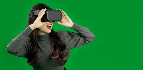 Metaverse Concept. Happy Young asian woman wear vr headset watching, playing, touching on green screen background.