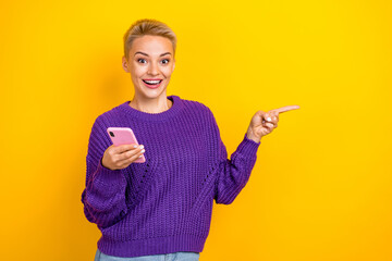 Photo of surprised shock short blonde hair wear knit violet sweater samsung phone finger point mockup cheap price isolated on yellow color background