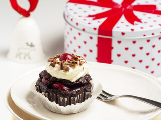 Black forest cake, Schwarzwald. Cake with dark chocolate, whipped cream and cherry on a muffins paper.