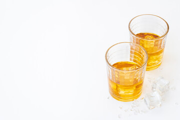 Golden whiskey in glass with ice. Strong alcohol background
