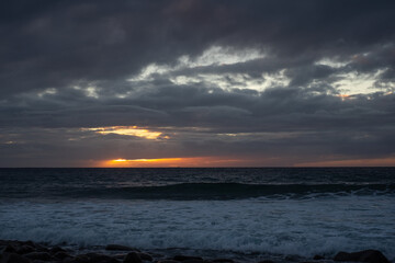Dramatic sky and orange sunset from the beach - atlantic ocean in Tenerife, canary islands. Travel and vacation concept