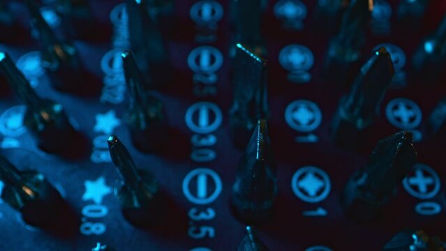 Screwdriver bits appear and disappear illuminated with colored light.