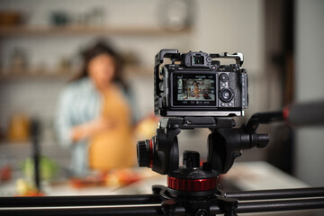 Fototapeta na wymiar Beautiful pregnant woman filming cooking vlog. Happy woman filming her blog about healthy food at home.