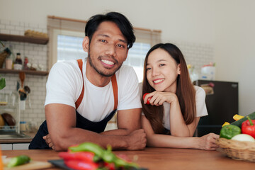 Portrait of young asian couple making salad together at home. cooking food and Lifestyle moment and healthy.