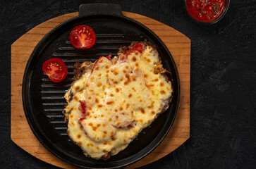 Grilled meat baked with cheese and tomatoes