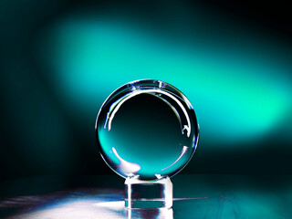 Glass ball on a metal surface and blue cyan color light painting in the background. Abstract art...