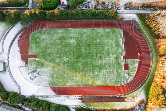 Running track covered with snow. Winter cold season time. Aerial top down view.