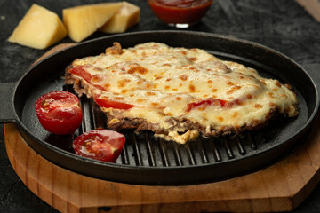 Grilled meat baked with cheese and tomatoes