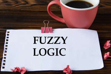 FUZZY LOGIC - word on a white sheet on a wooden brown background with a cup of coffee and a pen