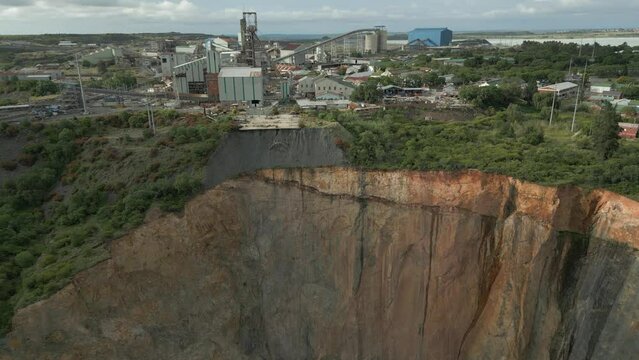 Low aerial view of dangerous scaling erosion of open pit mine wall