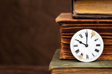 Old antique books and vintage clock face with copy space. Story time, storytelling background.