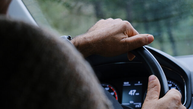 Hombre caucásico conduciendo un coche de forma responsable durante el día