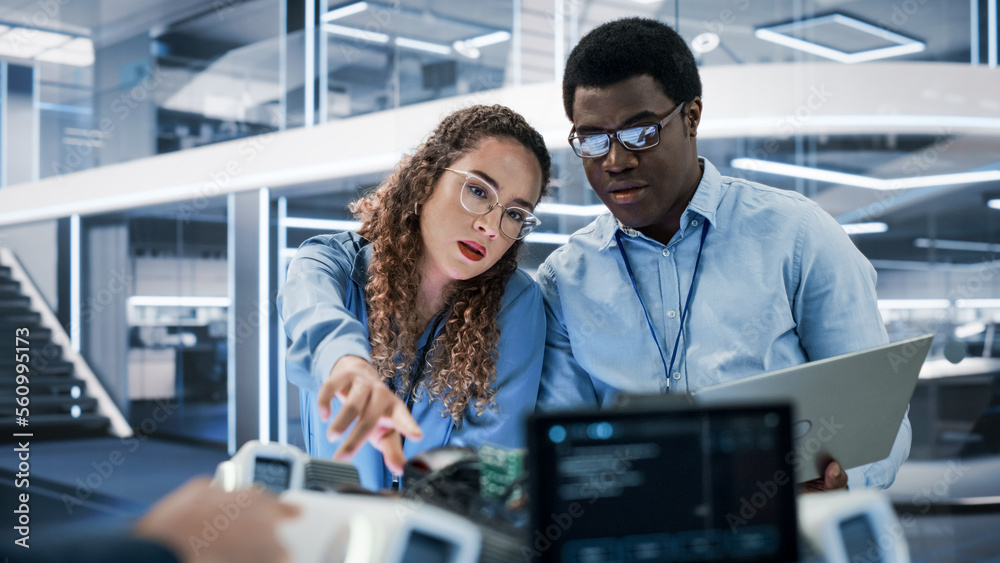 Poster Portrait of Two Multicultural Industrial Robotics Engineers Using Laptop Computer to Work on a Robot Dog. Colleagues Setting Up the Interface for a Mobile AI Robot Concept.
