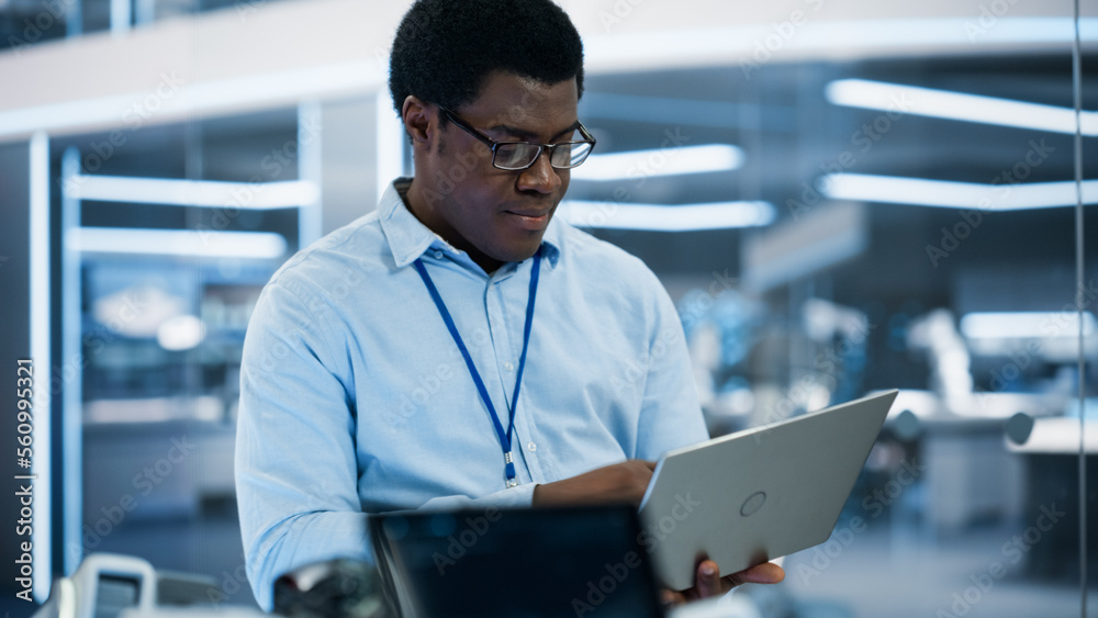 Aufkleber Handsome Black Man Wearing Glasses Using Laptop Computer. Young Intelligent Male Engineer or Scientist Working in Laboratory. Technology Office Background. Close Up Portrait.