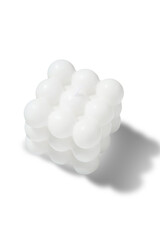 Subject shot of a figured white candle in the shape of a neocube. The designer handmade neocube candle is isolated on the white background.