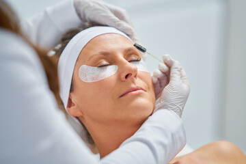 Woman having cosmetology eyebrows treatment in beauty salon