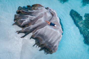 Woman lying on a granite rock disguised wearing a white rabbit mask to hide her identity