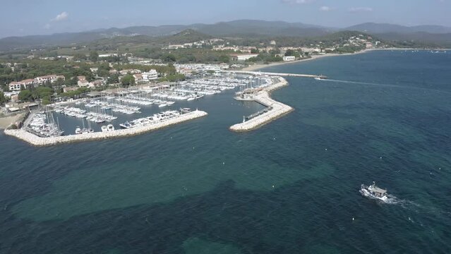 Drone sur un port avec des petits bateaux &agrave; moteur qui rentrent dans le port  