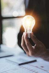 Man hold glowing light bulb, Creative new idea. Innovation, brainstorming, strategizing to make the business grow and be profitable. Concept execution, strategy planning and profit management