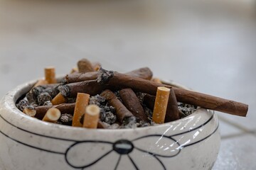 burning cigar in an overloaded ashtray
