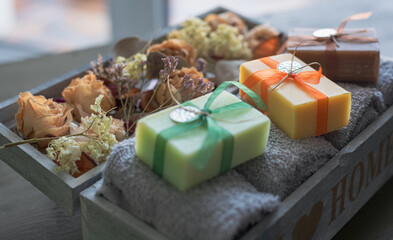 Handmade soap in a wooden box with towels and dried flowers
