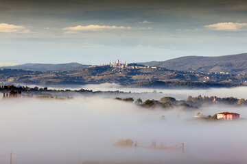 San Gimignano, Siena. Paesaggio con nebbie all'alba verso la cittadina 